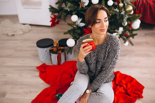 Femme buvant du thé le soir de Noël