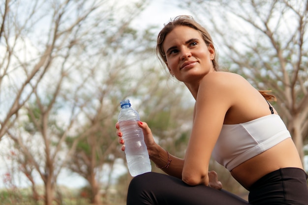 Femme buvant de l'eau dans le parc. bali