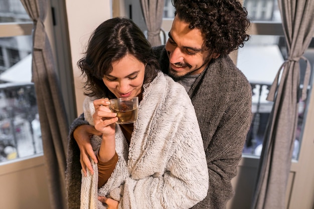 Femme buvant une tasse de thé à côté de son mari