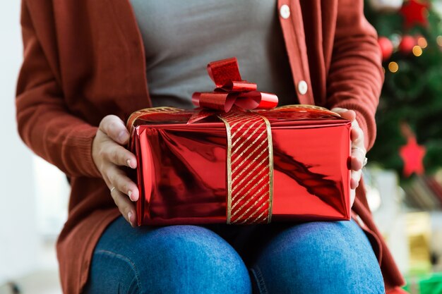 Femme avec un cadeau rouge sur ses genoux