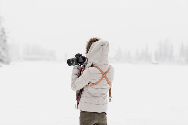 Femme avec caméra debout en hiver