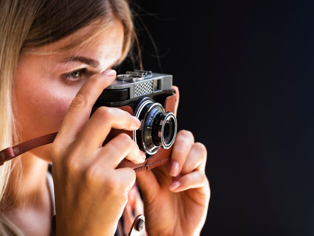 Femme avec caméra prenant des photos