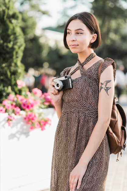 Femme avec caméra et sac à dos