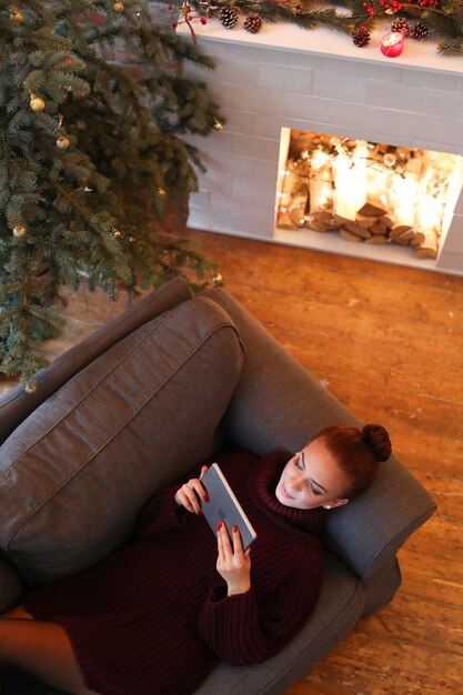 Femme sur le canapé avec une tablette