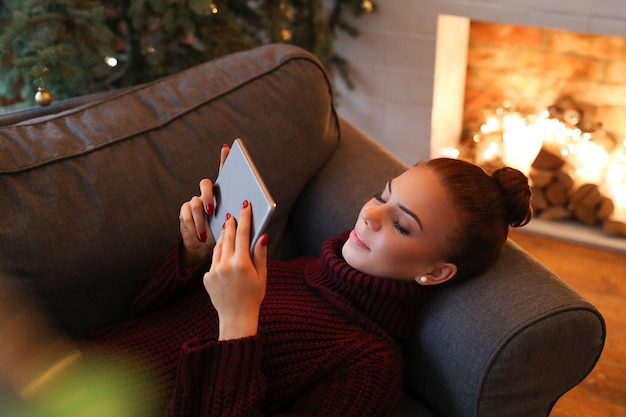 Femme sur le canapé avec une tablette