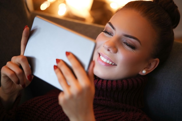 Femme sur le canapé avec une tablette