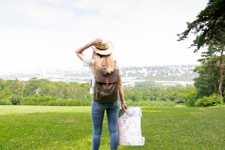 Photo gratuit la femme avec la carte tient son chapeau.