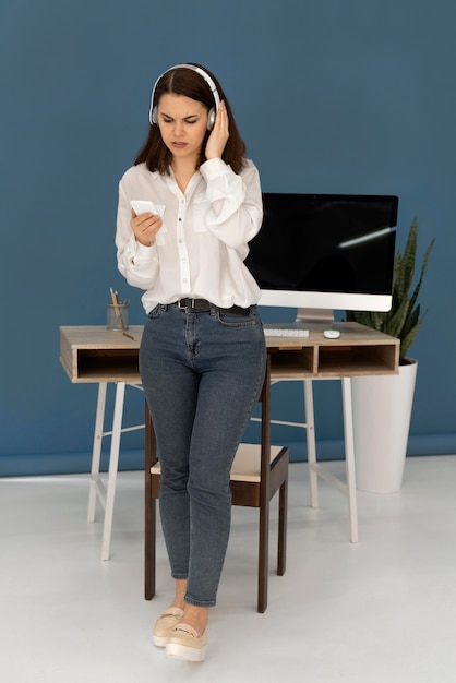 Femme avec un casque à l'aide de mobile