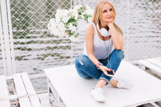 Femme avec un casque assis sur une table