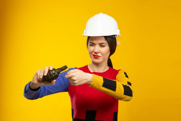 Photo gratuite femme en casque de chantier avec réplique de grenade à main