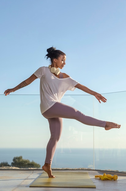 Femme avec un casque faisant du fitness à la maison