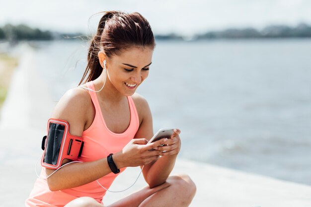 Femme avec un casque vérifiant son téléphone