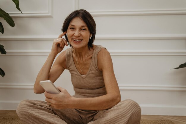 Une femme caucasienne adulte souriante aime commander des marchandises le week-end sur l'application téléphonique Concept de magasinage en ligne