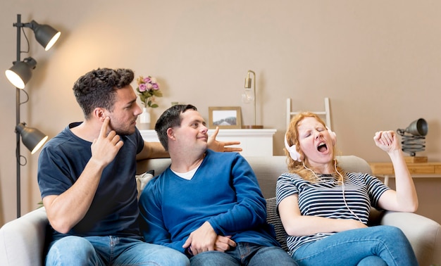 Femme chantant fort à côté d'amis tout en portant des écouteurs