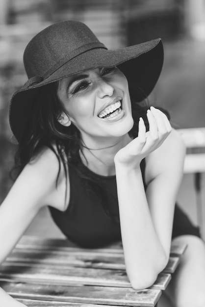 Femme avec un chapeau noir rire