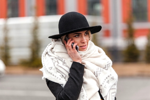 Femme avec un chapeau parlant au téléphone