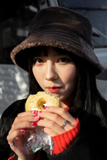 femme, à, chapeau seau, manger, pâtisserie