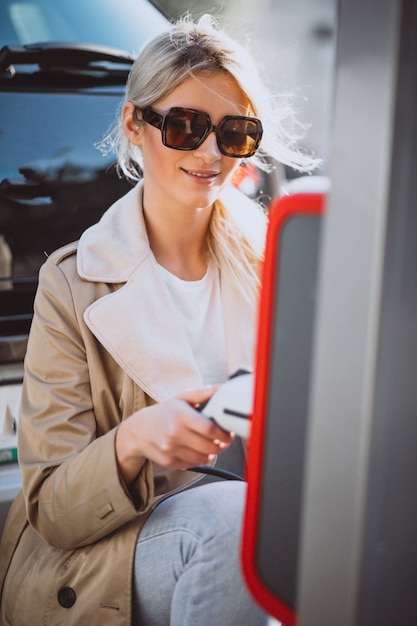 Photo gratuite femme chargeant une voiture électrique à la station d'essence électrique