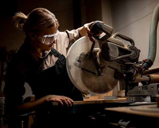 Femme charpentière avec des lunettes de sécurité et un outil