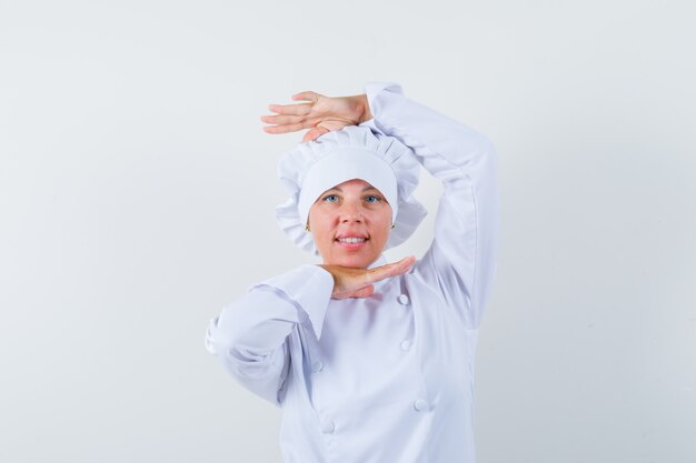 femme chef montrant le geste de danse en uniforme blanc et à la recherche de charme.