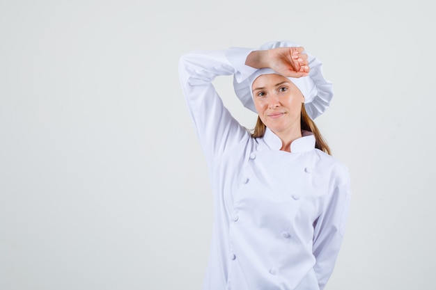 Femme Chef Posant Avec Le Bras Sur La Tête En Uniforme Blanc Et à La Joie