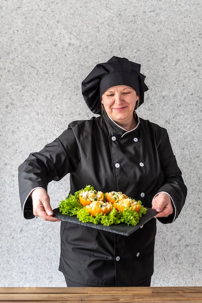 Femme chef présentant une salade de fruits