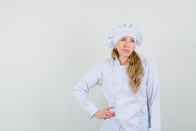 Femme chef à la recherche de suite en uniforme blanc et à la pensif