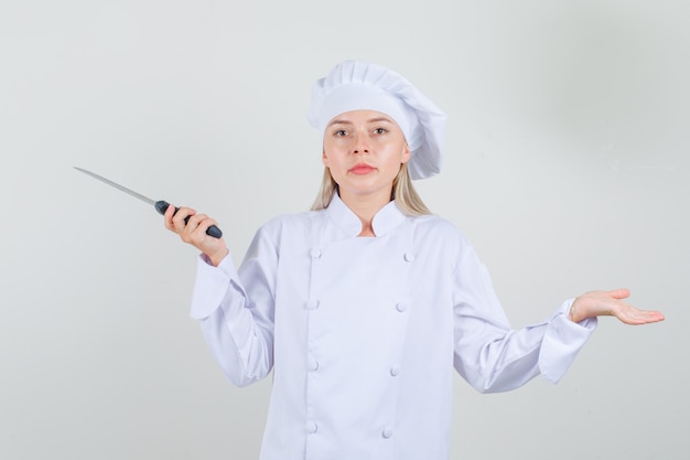 Femme Chef Tenant Un Couteau En Uniforme Blanc Et à La Recherche De Sérieux.