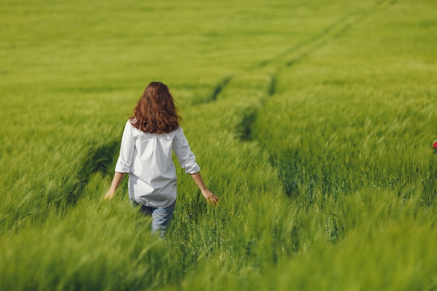 Femme en chemise bleue dans un champ d'été