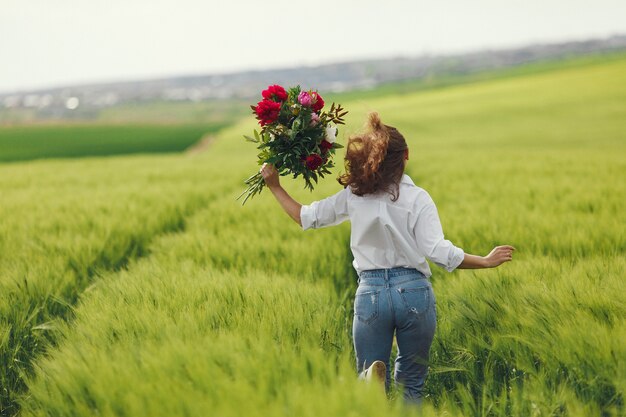 Femme en chemise bleue dans un champ d'été