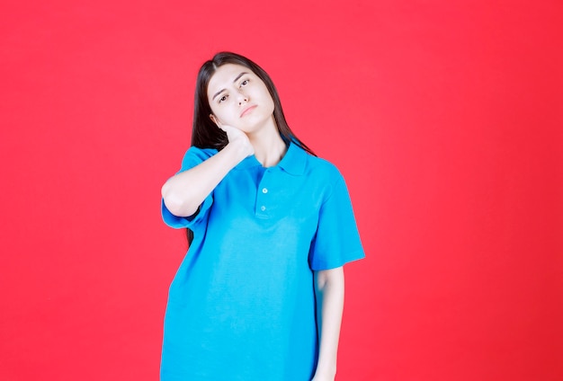 femme en chemise bleue debout et a l'air fatigué et somnolent.