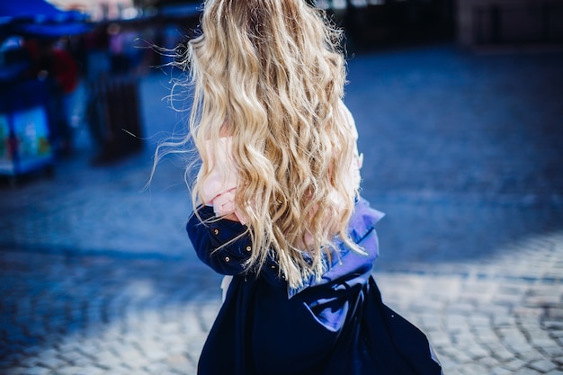 Femme en chemise bleue se promène le long de la rue