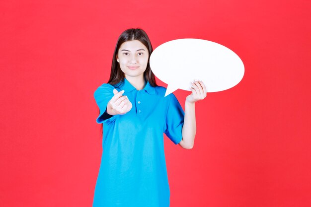 femme en chemise bleue tenant un panneau d'information ovale et demandant de l'argent.