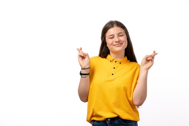 Femme en chemise jaune et jean bleu posant avec une expression heureuse sur les vêtements de modèle femme fond blanc