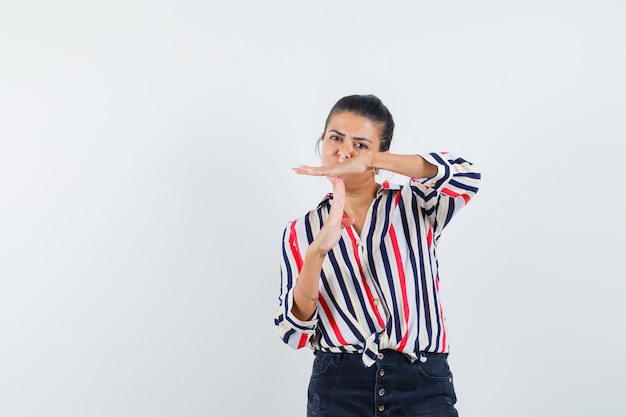 Femme en chemise, jupe montrant le geste de pause et à la confiance