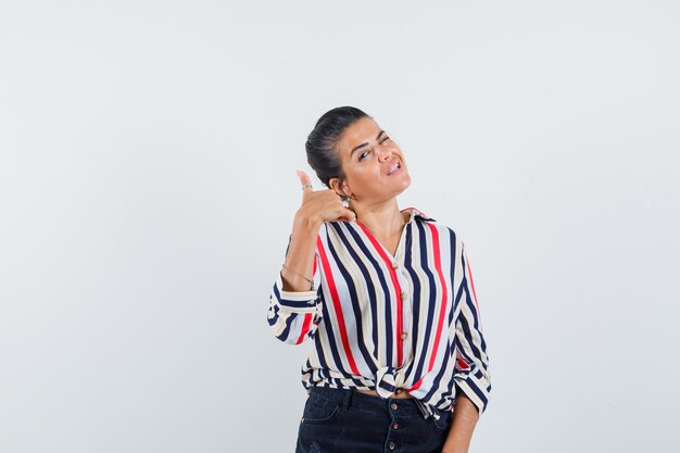 femme en chemise, jupe montrant le pouce vers le haut et à la confiance