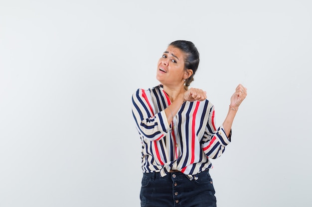 Femme En Chemise, Jupe Pointant Vers L'arrière Avec Les Pouces Et à La Confusion