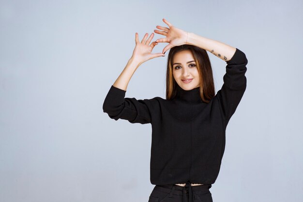 femme en chemise noire envoyant de l'amour à son partenaire.