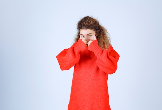 Photo gratuite une femme en chemise rouge a l'air terrifiée et effrayée.