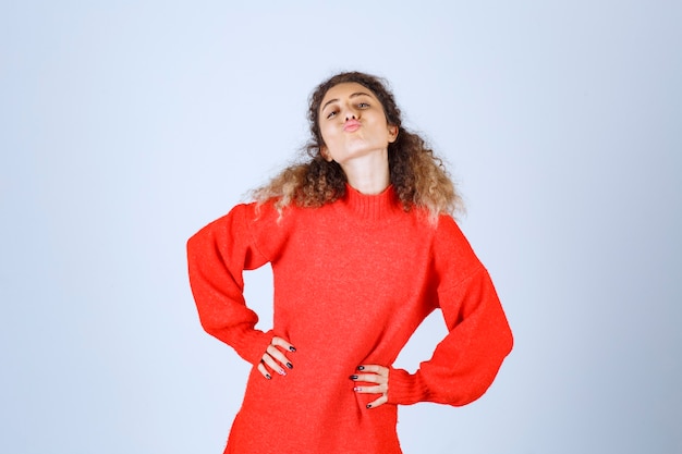 femme en chemise rouge soufflant l'amour à sa foule.