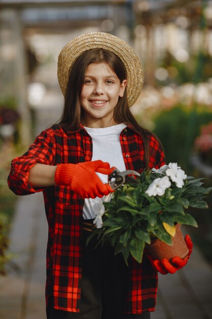 Femme en chemise rouge. Travailleur avec des pots de fleurs. Fille avec des plantes