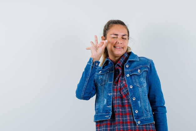 Femme en chemise, veste montrant le geste ok et à la vue de face, confiant.