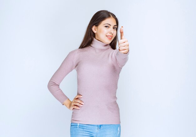 femme en chemise violette montrant le signe de la main de plaisir.