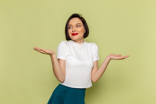 femme en chemisier blanc et jupe verte posant avec sourire