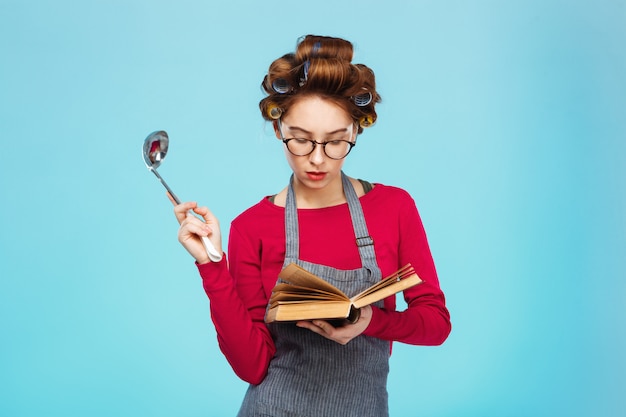 Femme cherche une nouvelle recette tenant une louche à soupe dans les mains