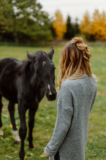 Femme sur un cheval au rancho. Équitation, temps de passe-temps. Concept d'animaux et d'humains