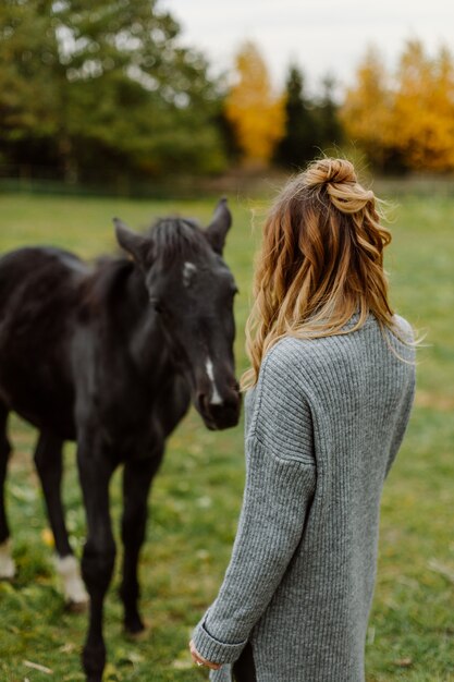 Femme sur un cheval au rancho. Équitation, temps de passe-temps. Concept d'animaux et d'humains