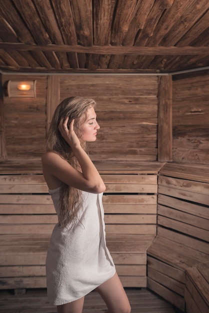 Photo gratuite femme avec les cheveux longs humides debout dans un sauna chaud