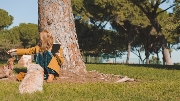 Femme avec un chien de caresse de livre