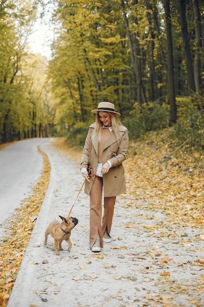 Photo gratuite femme et chien jouent et s'amusent dans le parc en automne